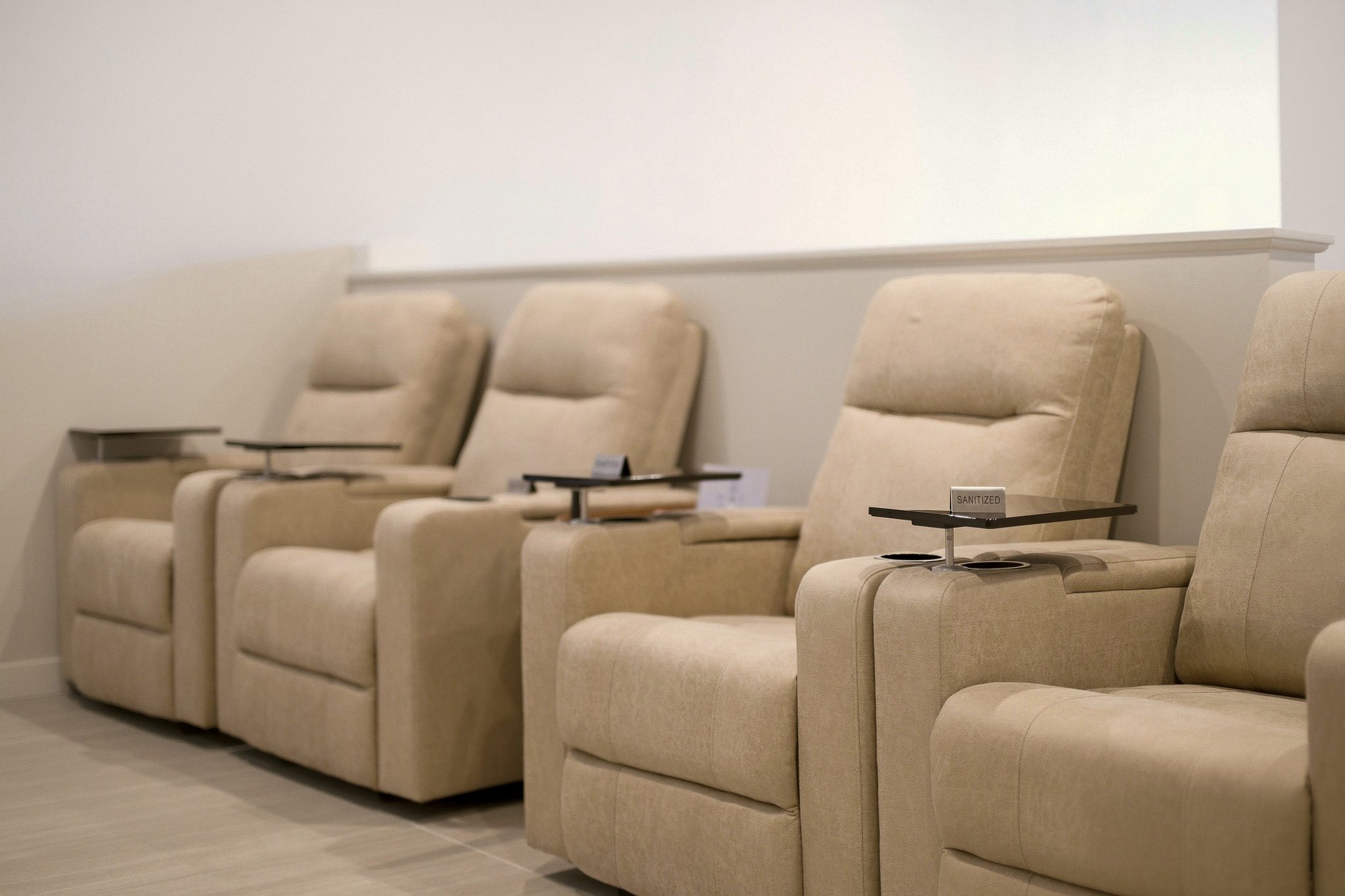 Row of cream leather treatment recliners with side tables in the Ovilla Medical & Wellness lounge